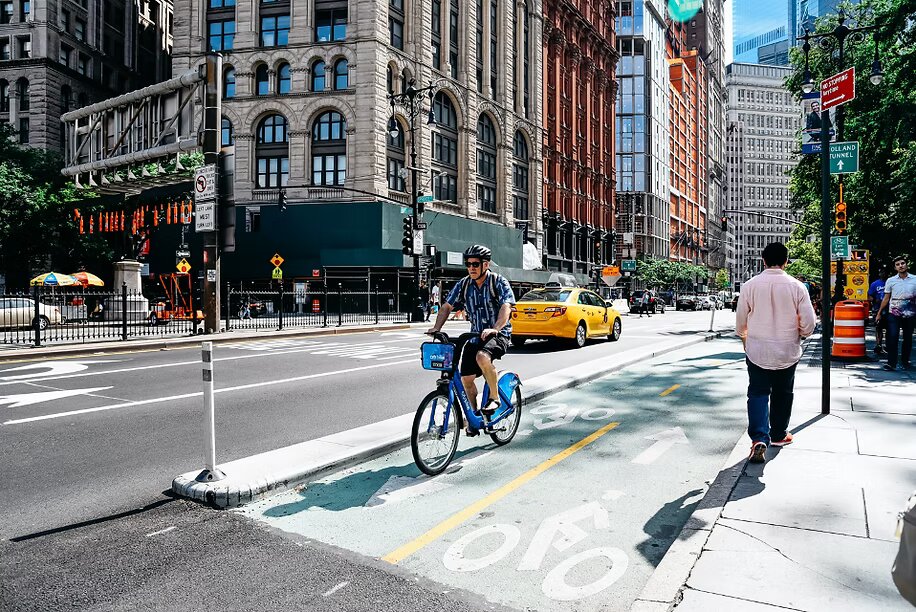 A cyclist riding in a protected bike lane in a city